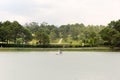 A view of the green golf course across the Ho Xuan Huong lake in the hill town of Dalat Royalty Free Stock Photo