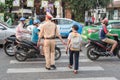 Da Nang, Vietnam: a Vietnamese traffic policeman takes a boy across the busy street