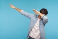 Dab dance. Portrait of man in denim shirt making dabbing movement, famous internet meme of success victory