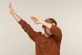 Dabbing movement. Portrait of optimistic carefree man wearing sweatshirt standing in dab dance pose