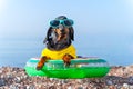 Dachshund in sunglasses sits in inflatable swimming ring on seashore. Royalty Free Stock Photo