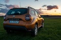 Dacia Duster compact SUV on gravel road at sunset