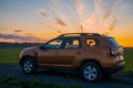Dacia Duster compact SUV on gravel road at sunset Royalty Free Stock Photo