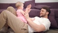 Dad with baby playing hands. Smiling father and toddler girl play with hands