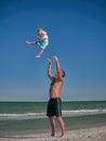 Dad and Baby playing on seaside in summertime. Happy family and happy childhood concept. Little boy having fun with Royalty Free Stock Photo