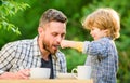 Dad and boy eat and feed each other outdoors. Ways to develop healthy eating habits. Feed your baby. Natural nutrition