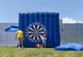 Dad and boy having fun with giant inflatable dart board outside/outdoor