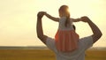 Dad carries on shoulders of his beloved child, in rays of sun. Father walks with his daughter on his shoulders in rays Royalty Free Stock Photo