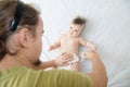 Dad changing diaper on baby girl on bed, changing nappy, everyday care