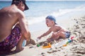 Dad with a child build castles in the sand. Childhood