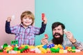 Dad and child build plastic blocks. Happy family. Child development and upbringing. Importance of playing together. Dad