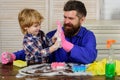 Dad and child doing cleaning at home. Father and son with cleaning supplies on. Parents and child with rubber glove in Royalty Free Stock Photo