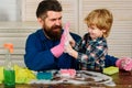 Dad and child doing cleaning at home. Father and son with cleaning supplies on. Parents and child with rubber glove in Royalty Free Stock Photo