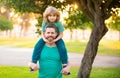 Dad and child having fun outdoors. Father giving son ride on back in park. Portrait of happy father giving son piggyback Royalty Free Stock Photo