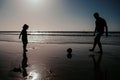 Dad and child having fun outdoors. Father and son play soccer or football on the beach on summer family holidays Royalty Free Stock Photo