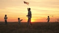 Dad with children plays with kites at sunset in the park. Outdoor family game. Daddy and healthy daughters are launching Royalty Free Stock Photo