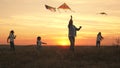 Dad with children plays with kites at sunset in the park. Outdoor family game. Daddy and healthy daughters are launching Royalty Free Stock Photo