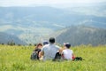 Dad and children are sitting on the top of the mountain, resting. The family looks at beautiful views from above. Family trip Royalty Free Stock Photo