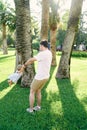 Dad circles the little girl under the palm trees on the green lawn Royalty Free Stock Photo