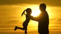 Dad is circling his beloved healthy daughter in his arms. silhouette of father and child at sunset. happy daddy and Royalty Free Stock Photo