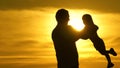 dad is circling his beloved healthy daughter in his arms. silhouette of father and child at sunset. happy daddy and Royalty Free Stock Photo