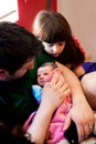 Dad Cradles Newborn Big Sister Looks On