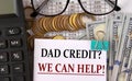 DAD CREDIT? WE CAN HELP! - words on a white piece of paper on the background of a calculator, pennies and glasses Royalty Free Stock Photo