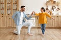 Dad dancing to music with preteen daughter at home kitchen Royalty Free Stock Photo