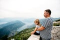 Dad and daughter in common family look stand on the view point and look at the Kotor Bay in Monenegro. Traveling family concept