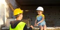 Dad and daughter are at construction site of their future home. The choice of the future profession of a builder is inherited by Royalty Free Stock Photo