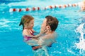 dad and daughter cuddle and swim in the pool. swimming training.