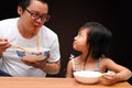 Dad and daughter are eating instant noodles