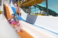 Dad and daughter are happy going down slide in water park. Royalty Free Stock Photo