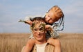 Dad and daughter. Man plays with little girl in nature. Child with red hair close fathers eyes with flowers