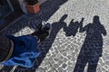 Dad, daughter, mom are playing in the street during the visit at the historical city - Shadows of happy female child is holding Royalty Free Stock Photo