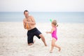 Dad and daughter play water pistols on the sea Royalty Free Stock Photo