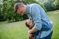 Dad with daughter, playing at meadow, hugging, having fun. Concept of fathers& x27;s Day and fatherly love. Royalty Free Stock Photo
