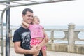 Dad and daughter playing promenade by the sea. young man, little girl hanging on the bar. Royalty Free Stock Photo