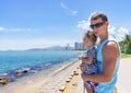 Dad and daughter playing on the promenade by the sea. young man, little girl Royalty Free Stock Photo