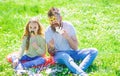 Dad and daughter sits on grass at grassplot, green background. Child and father posing with eyeglases and mustache photo