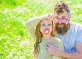 Dad and daughter sits on grass at grassplot, green background. Fatherhood concept. Family spend leisure outdoors. Child Royalty Free Stock Photo