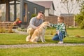 Dad and daughter spending time with their fluffy canine