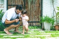 Dad and daughter walking, father helps child to make baby steps, barefooted outdoor