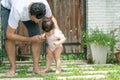 Dad and daughter walking, father helps child to make baby steps, barefooted outdoor
