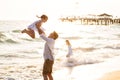 Dad with daughters walking along sea-shore in windy weather. fun family