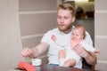 Dad feeds his naughty baby who refuses to eat fruit puree Royalty Free Stock Photo