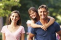 Dad Giving Daughter Piggyback On Family Walk Through Summer Park Royalty Free Stock Photo