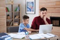 Dad helping his son with difficult homework assignment in room Royalty Free Stock Photo