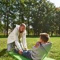 Dad helping teenage son crunching on fitness mat