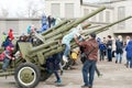 Dad helps daughter to get off the antiaircraft gun, which is standing near the museum of the Victory Memorial.